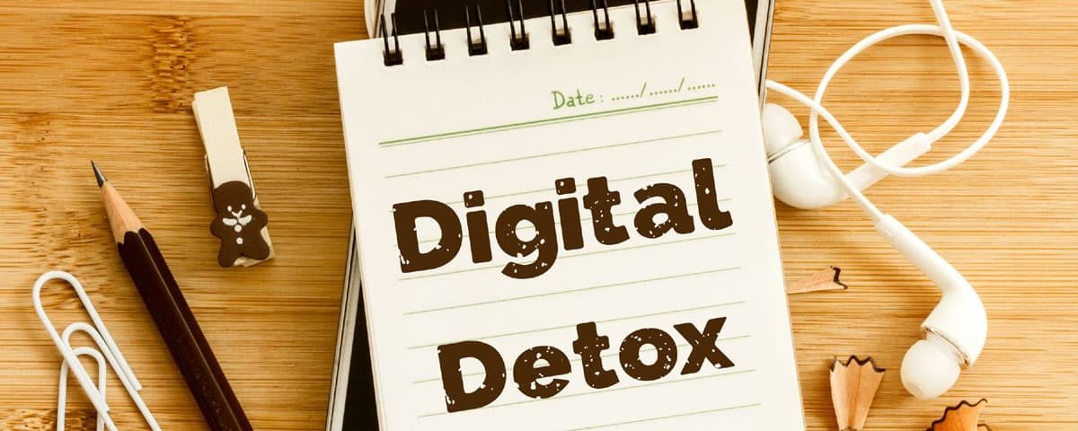 Persoon legt smartphone weg en pakt een wekker/boek; rustige kamer met zacht licht — symbool voor een digitale detox en meer focus.