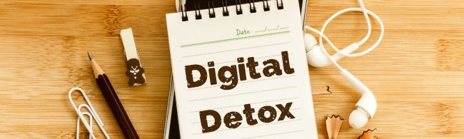 Persoon legt smartphone weg en pakt een wekker/boek; rustige kamer met zacht licht — symbool voor een digitale detox en meer focus.