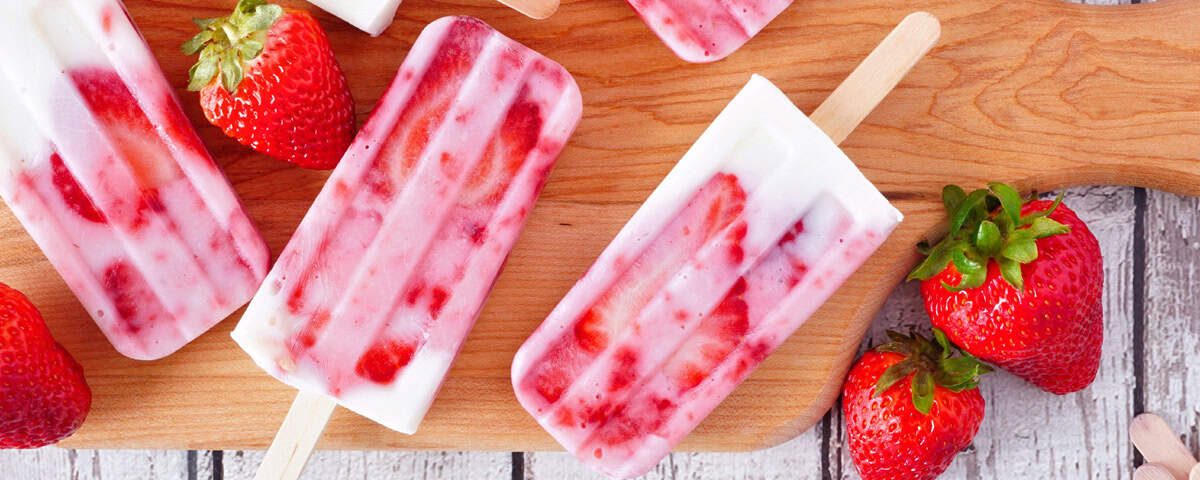 IJsjes in vormpjes met stukjes aardbei zichtbaar – romig en verfrissend aardbei-yoghurt ijsje als verantwoorde traktatie.