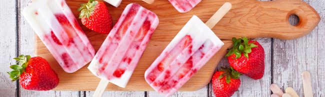 IJsjes in vormpjes met stukjes aardbei zichtbaar – romig en verfrissend aardbei-yoghurt ijsje als verantwoorde traktatie.