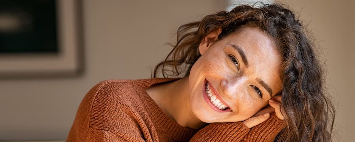 Persoon in een schemerig winterse setting, licht van een wake-up lamp en knusse sfeer — symboliseert het tegengaan van een winterdip met licht en warmte.