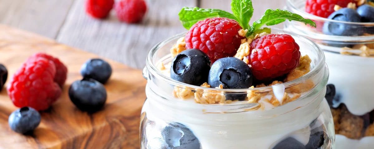 Zomerse yoghurt parfait met vers rood fruit, granola en yoghurt in laagjes – fris ontbijt of licht dessert.