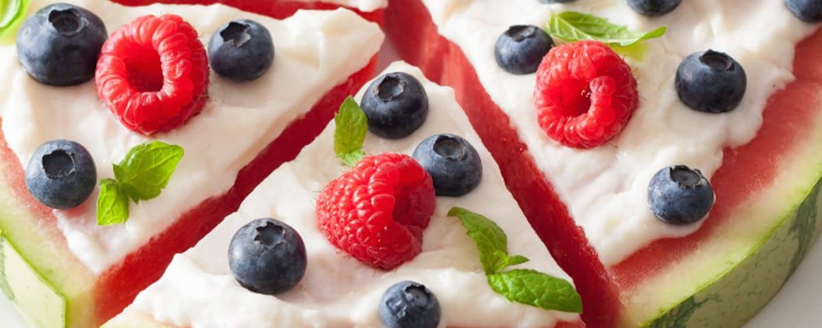 Tien gezonde tussendoortjes onder de 200 kcal, zoals fruitige watermeloen pizza met yoghurt, groentesticks, edamame en lichte eiwitrijke snacks.