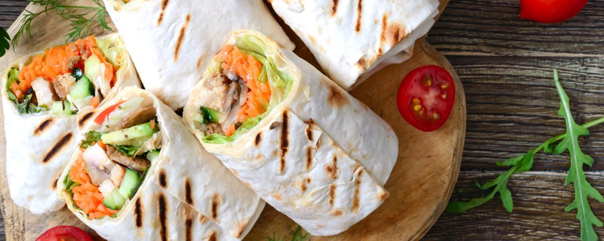 Lichte volkoren wraps gevuld met hummus, wortel, komkommer, rucola en ei – voorjaarsgerecht.