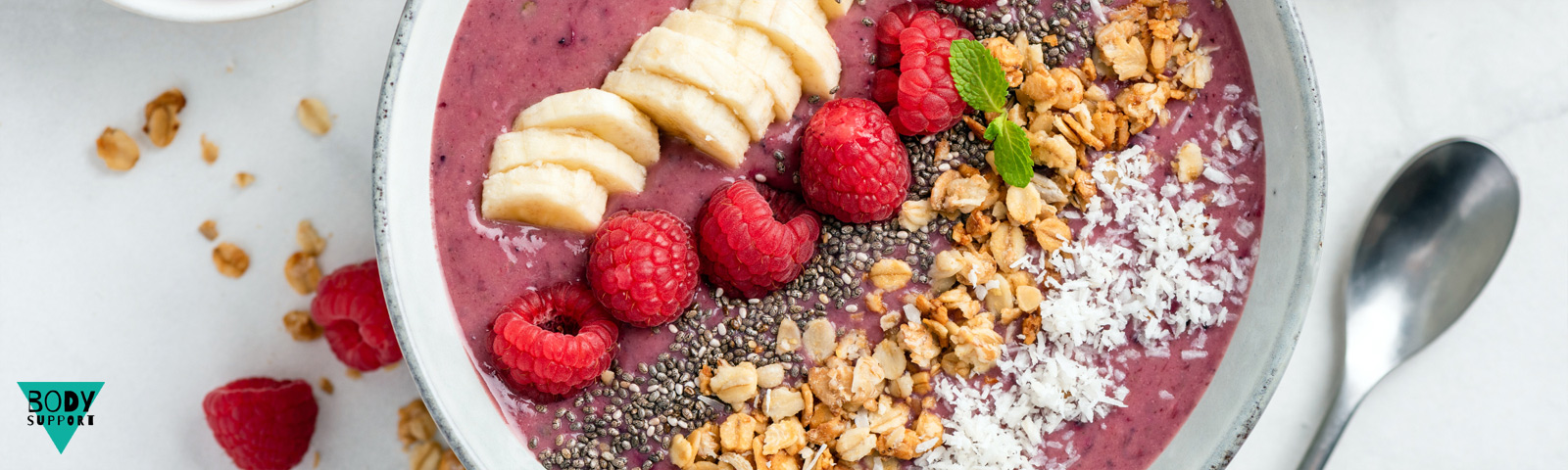 Zomerse smoothie bowl met framboos en kokos, geserveerd met frisse toppings.